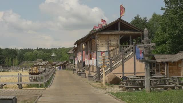 Observation Building With a Flags Near Sandy Stadium, People Distantly