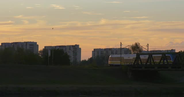 River Bank Buildings on Opposite Bank Train is Moving by Bridge Toward the City Through the River Tw
