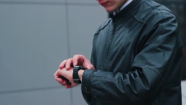 Stylish Man Using Smart Watch Standing Near the Office.