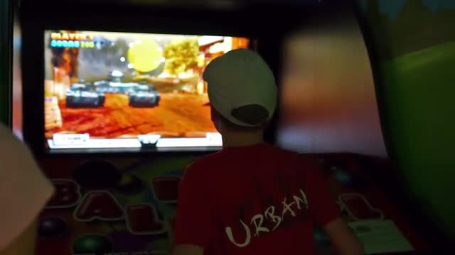 Kid Playing Arcade Video Game at an Amusement Park