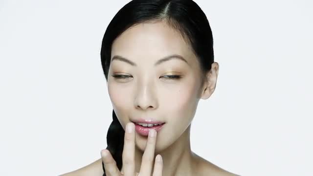 Young woman applying lipgloss