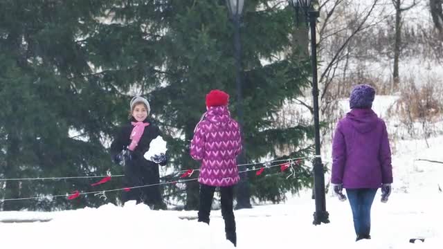Kids Having Fun and Playing Snowballs in Cold Winter Day