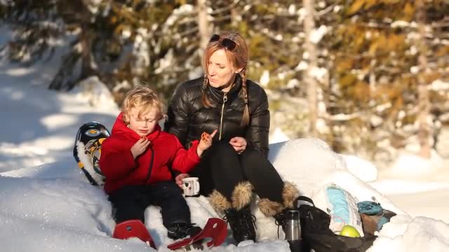 Caucasian mother and son having picnic in snow