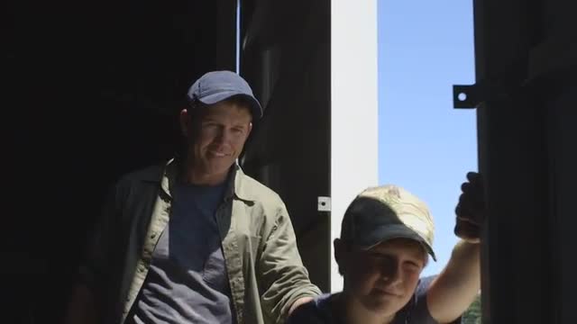 Caucasian father and son opening barn door