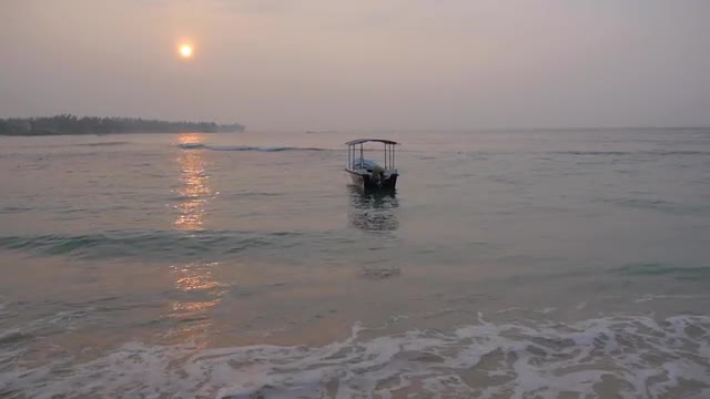 Calm sea with a alone sway boat at sunrise, Sri lanka, Unawatuna beach