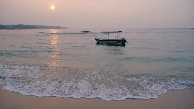 Calm sea with a alone sway boat at sunrise, Sri lanka, Unawatuna beach