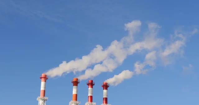 Factory in the City. From the pipes of the plant goes white smoke. The plant is located in the city.