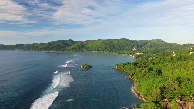 Aerial view of Anse Royale coast with clear sea water of Indian Ocean and green luxuriant hills