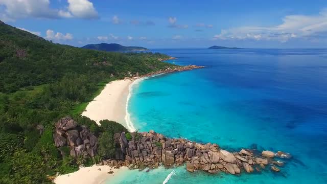 Aerial view of tropical paradise beach with white sand and turquoise water - Grand Anse, Seychelles