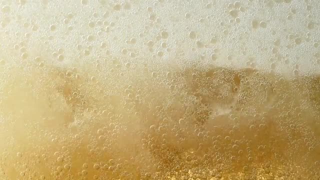 Pouring ginger ale in a glass with ice