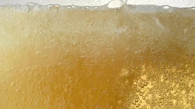 Pouring ginger ale in a glass with ice