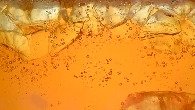 Pouring iced tea in a glass with ice