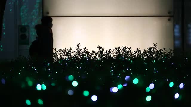 Christmas illuminations and people silhouette walking in the background