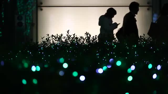 Christmas illuminations and people silhouette walking in the background