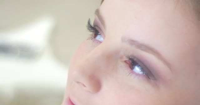 Stylist is Straightening the Lash After Putting Mascara Making a Makeup Model Face Close up Smiling 