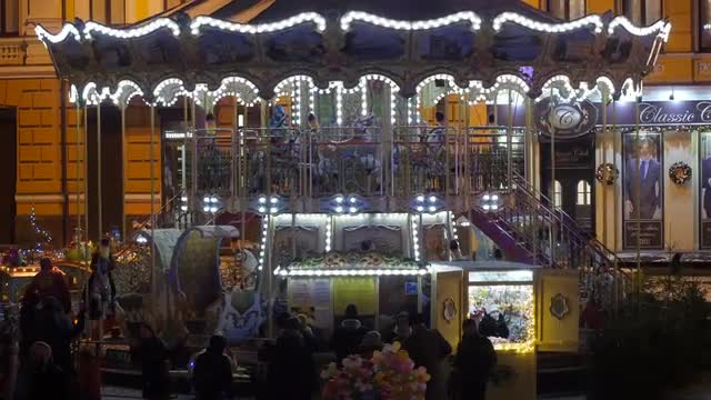 People Are Looking at Carousel Rotating at Square Decorated With Lights Families Kids New Year's