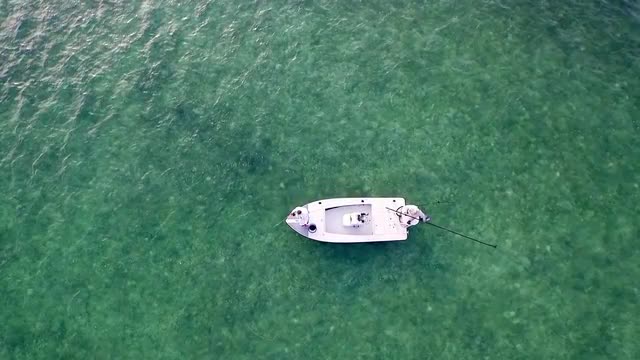 Aerial view of distant Caucasian men fly fishing on skiff boat