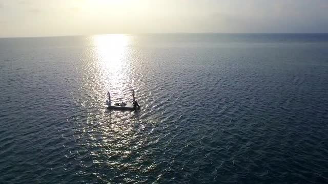 Silhouette of distant Caucasian men fly fishing on skiff boat