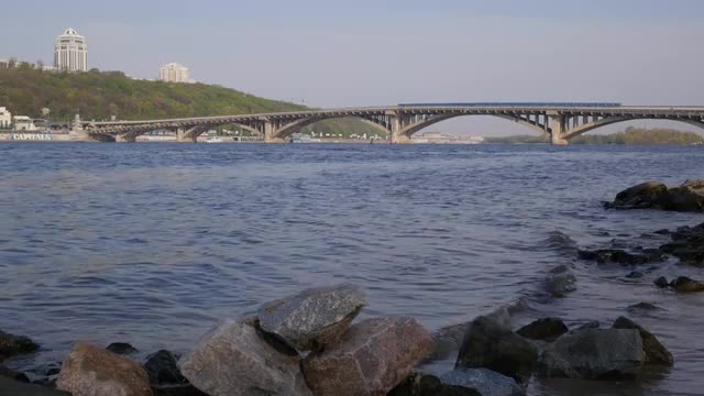 the Foreground Seen Dashing Waves of the River Bridge Over the River is Located Behind