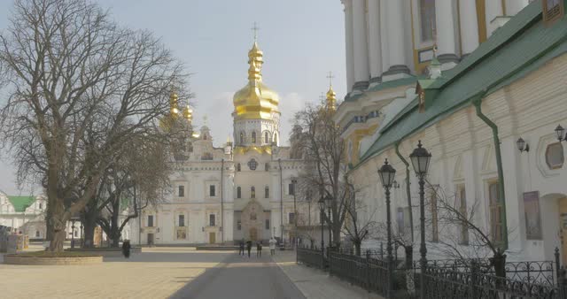 People Are Walking Close to Dormition Cathedral of Kievo-Pecherska Lavra Golden Cupola Trees Without