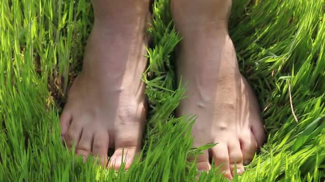Woman Walking Barefoot on the Grass