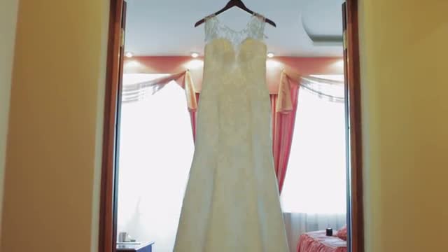 White Wedding Dress Hanging at Doorway