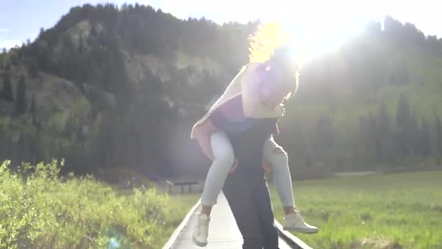 Teenage Boy Gives Girlfriend A Piggyback Ride, Twirls Around, Then Runs, She Covers His Eyes (Slow M