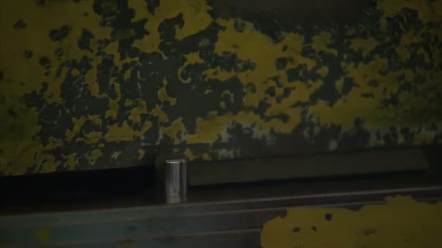 Close up of a machine being a metal plate in half.