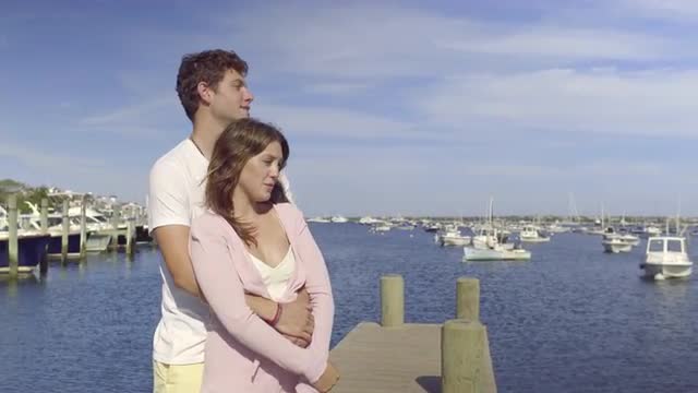 Attractive Couple Embrace And Enjoy Ocean Views From Dock 