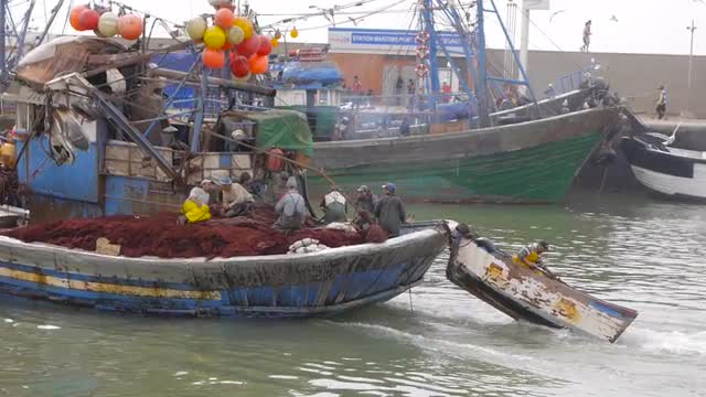 fisherman boat tows another boat to sea, essaouira, morocco
