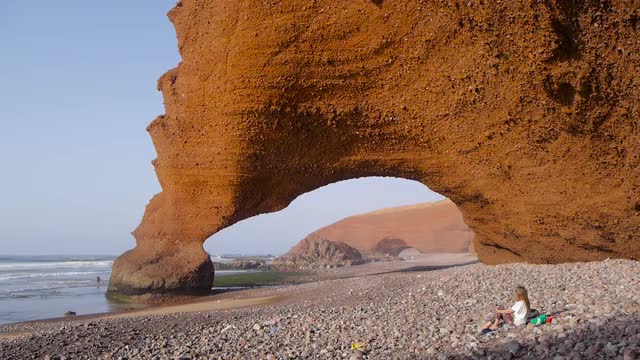 Girl relaxing on legzira beach, morocco