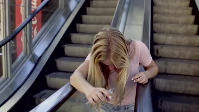 Teenage Girl Spins Around On Escalators, She Gets Stuck Between Them, Laughs Hysterically (Slow Moti