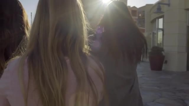 Girls Walk Around Outdoor Mall Together, Shot From Behind In Slow Motion