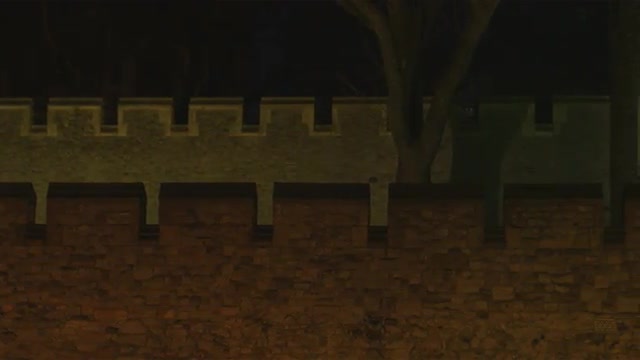Panning shot of a castle wall at night