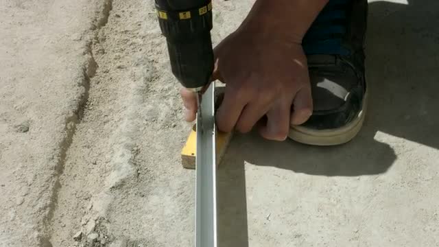 Worker Makes Apertures in a Bar With a Drill. the Installation of Partitions