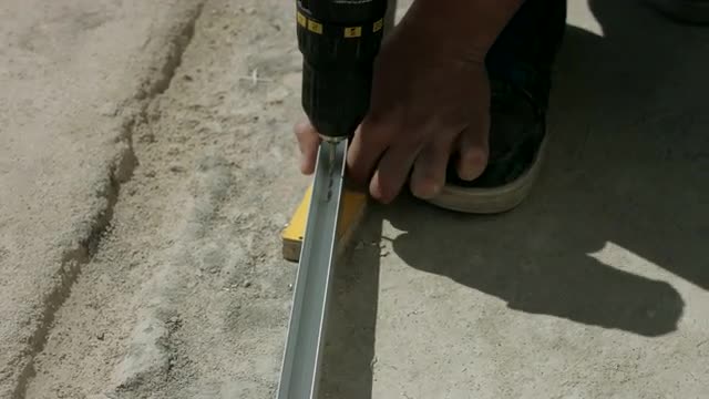 Worker Makes Apertures in a Bar With a Drill. the Installation of Partitions