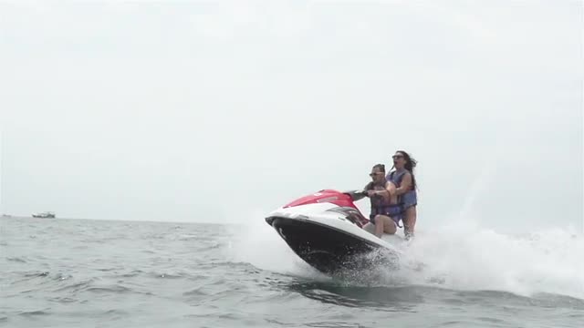 People Rid On Water Scooter