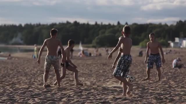 Friends Playing Football On Beach