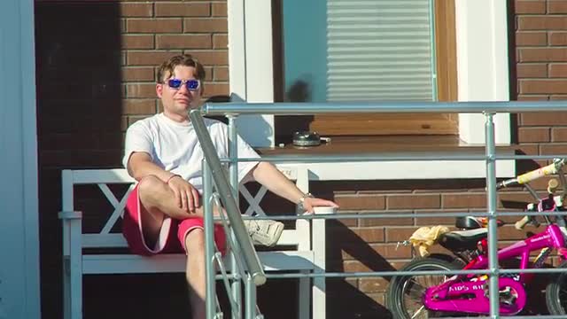 Stylish Man On A Bench Near The House