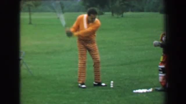 1969: Golfing trick shot professional performance man one handed wedge strike.