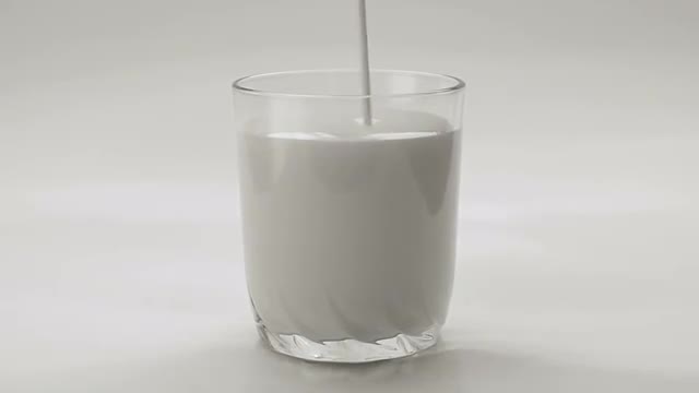 Pouring White Yogurt Into Transparent Glass on White Background