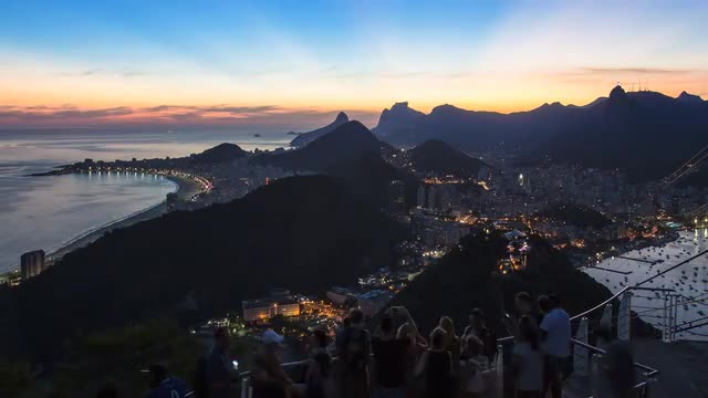 Tourists viewing Christ the Redeemer on Mount Corcovado and the city at sunset from Sugarloaf (Pao d