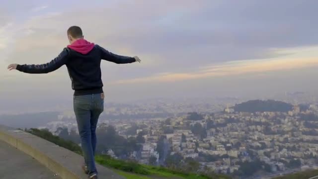 Man Walks Along Wall At A Scenic Overlook In San Francisco 