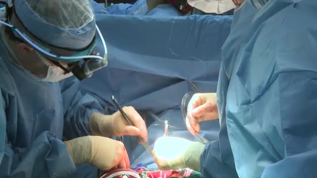 Pan down to heart surgery in progress
