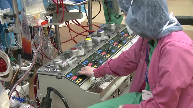 Technician monitoring heart lung bypass machine (1 of 2)