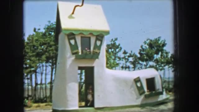 1955: Storyland theme park old women in a shoe house building boy waving window. GLEN, NEW HAMPSHIRE