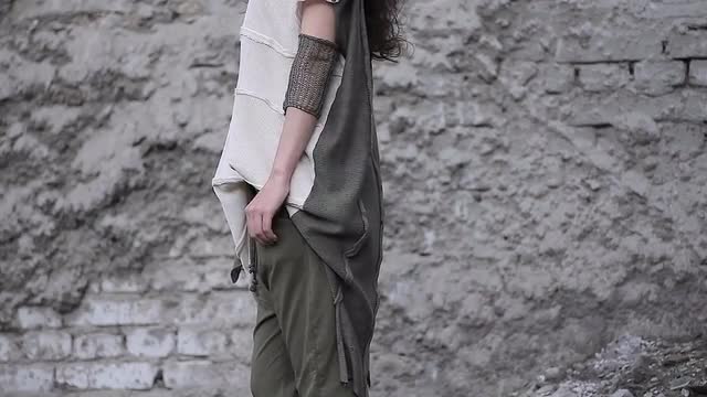 Woman in Futuristic Dress on a Background of a Stone Wall