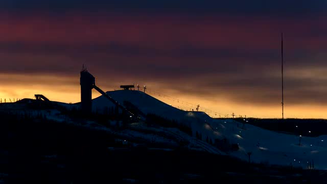 Orange sunset behind ski hill