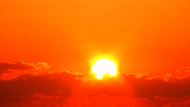 Sun rising up against the clouds