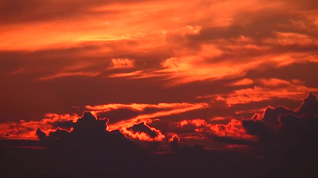 Sun hidden behind the clouds in the red sky